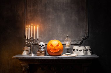 Korkunç gülen balkabağı ve eski kafatası antik gotik şöminede. Cadılar Bayramı, büyücülük ve sihir.