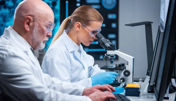 Professor e médico trabalham em um laboratório científico moderno usando equipamentos e computadorestecnologias. Grupo de cientistas fazer pesquisa e desenvolver novas vacinas. Conceito de ciência e saúde. — Fotografia de Stock