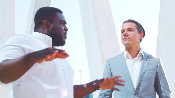 自信的非裔美国商人和他的同事在现代办公大楼前。金融投资者在室外谈论。银行和商业. — 图库视频影像