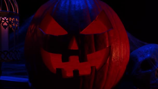 Skrattande pumpa och en gammal skalle med mörk bakgrund. Halloween, häxeri och magi. — Stockvideo