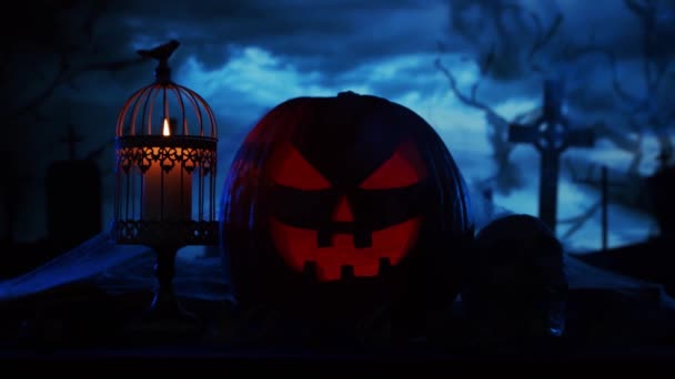 Ijesztő nevető tök és egy öreg koponya az ijesztő gótikus temetői háttér felett. Halloween, boszorkányság és varázslat. — Stock videók