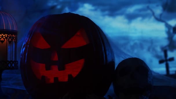 Ijesztő nevető tök és egy öreg koponya az ijesztő gótikus temetői háttér felett. Halloween, boszorkányság és varázslat. — Stock videók
