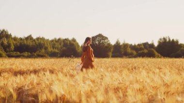 Günbatımında hamile bir kadın. Güzel bir genç kız bir çocuğun doğmasını umarak tarlada yürüyor. Annelik ve hamilelik kavramı.