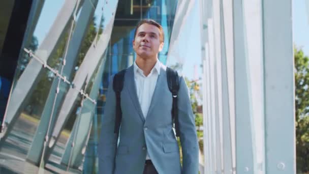 Selbstbewusster Geschäftsmann vor einem modernen Bürogebäude. Finanzinvestoren reden im Freien. Bank- und Geschäftskonzept. — Stockvideo