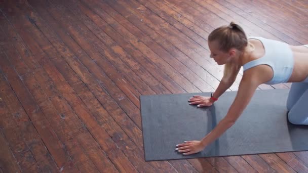 Jeune fille sportive en vêtements de sport fait des exercices à l'intérieur de la maison. Fit et mince femme blonde va dans le sport et de remise en forme. Soins de santé, combustion des graisses et bien-être. — Video