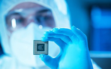 Bilim adamı mikro elektronik ve işlemcilerin araştırılması ve geliştirilmesi için modern bir bilim laboratuvarında çalışıyor. Mikroişlemci imalat işçisi bilgisayar teknolojisi ve ekipmanı kullanıyor.