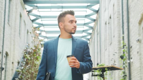 Un joven empresario exitoso está parado en la calle. Un hombre con ropa casual. Negocios, freelance y trabajo remoto. — Vídeos de Stock