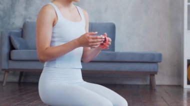 Spor giyim sektöründe genç ve sportif bir kız iç mekanda egzersiz yaparken akıllı saat kullanıyor. Formda ve narin sarışın kadın spor ve spor için geliyor. Sağlık sigortası, yağ yakma ve sağlık..