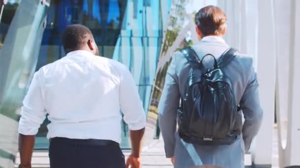 Fiducioso uomo d'affari afro-americano e il suo collega di fronte a un moderno edificio per uffici. Gli investitori finanziari stanno parlando all'aperto. Settore bancario e commerciale. — Video Stock