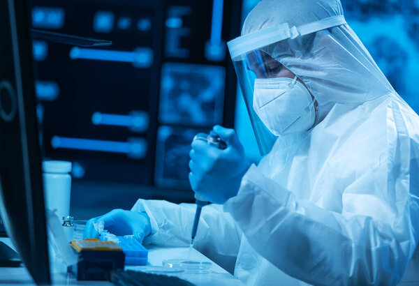 Ученый работает в современной научной лаборатории с использованием лабораторного оборудования, микроскопа и компьютерных технологий. Изобретение новых вакцин. Концепция науки и здравоохранения.