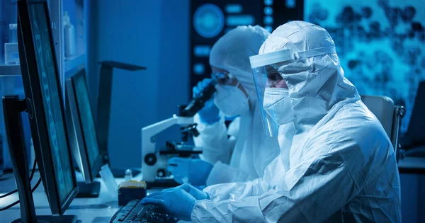 Los científicos trabajan en un laboratorio científico moderno utilizando equipos de laboratorio, microscopio y tecnología informática. Invención de nuevas vacunas. Concepto de Ciencia y Salud. — Foto de Stock