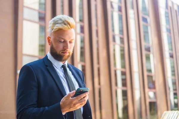 Selbstbewusster Geschäftsmann vor einem modernen Bürogebäude. Finanzinvestor setzt auf Smartphone-Outdoor Banken und Unternehmen. — Stockfoto