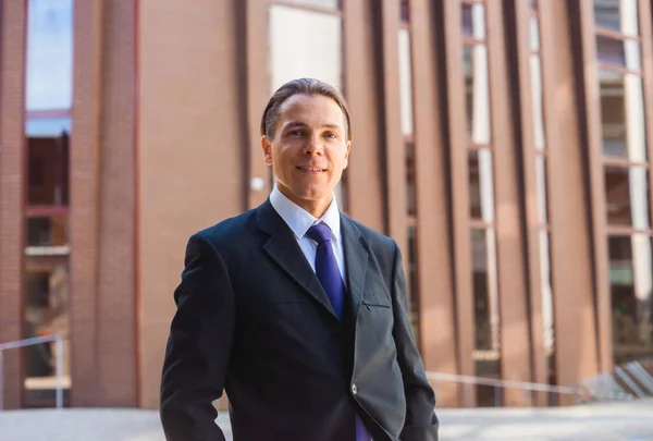 Un hombre de negocios seguro frente al moderno edificio de oficinas. El inversor financiero está caminando al aire libre. Banca y negocios. — Foto de Stock