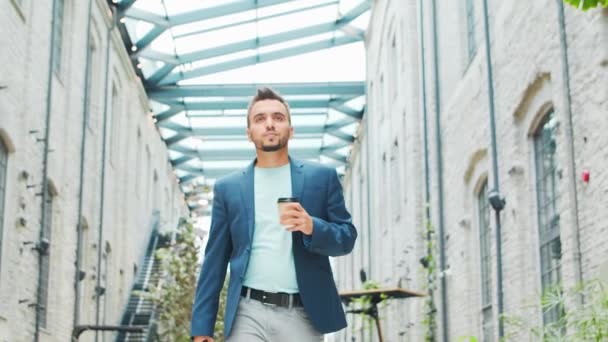 Un joven empresario exitoso está caminando por la calle. Un hombre con ropa casual. Negocios, freelance y trabajo remoto. — Vídeos de Stock