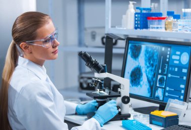 Kadın doktor, bilgisayar teknolojileri ve ekipman kullanarak modern bir bilim laboratuarında çalışıyor. Bilim adamı araştırma yapar ve yeni aşılar geliştirir. Bilim ve sağlık konsepti.