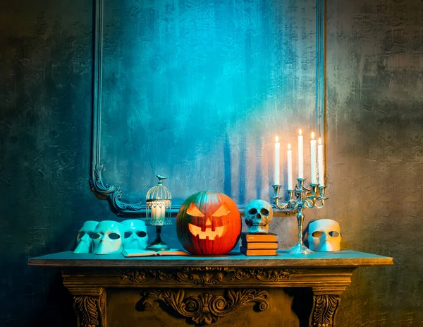 Scary laughing pumpkin and old skull on ancient gothic fireplace. Halloween, witchcraft and magic. — Stock Photo, Image