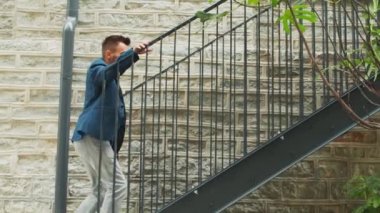 Genç ve başarılı bir işadamı merdivenlerden yukarı çıkıyor. Sıradan giysili bir adam. İş, serbest meslek ve uzak çalışma.