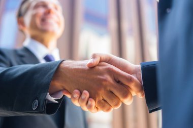 El sıkışın, yakın plan. İş adamı ve meslektaşı modern ofis binasının önünde el sıkışıyorlar. Finansal yatırımcılar açık havada. Bankacılık ve iş.