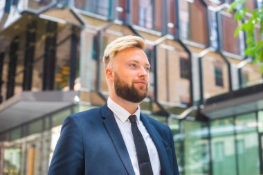 Modern ofis binasının önünde kendinden emin bir iş adamı. Finansal yatırımcı dışarıda dolaşıyor. Bankacılık ve iş.