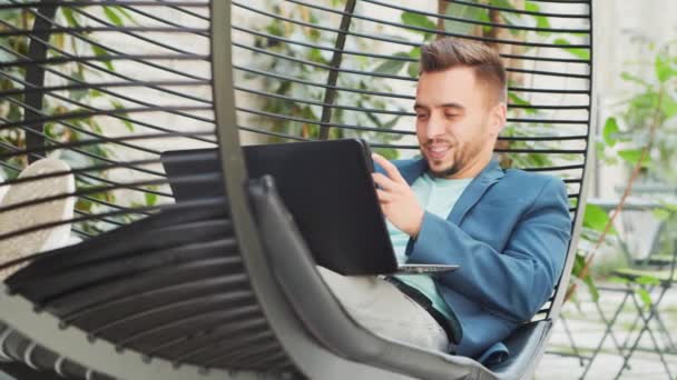 Giovane uomo d'affari caucasico di successo lavora in una sala utilizzando un computer. Affari, freelance e lavoro a distanza. — Video Stock
