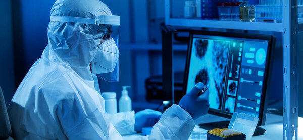 Ученый работает в современной научной лаборатории с использованием лабораторного оборудования, микроскопа и компьютерных технологий. Изобретение новых вакцин. Концепция науки и здравоохранения.