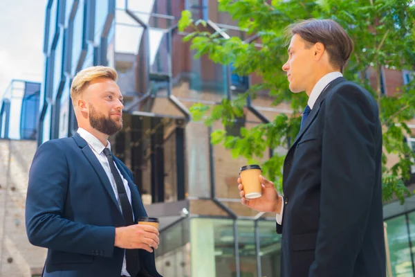 Självsäker affärsman och hans kollega framför en modern kontorsbyggnad. Finansiella investerare pratar utomhus. Banker och företag. — Stockfoto