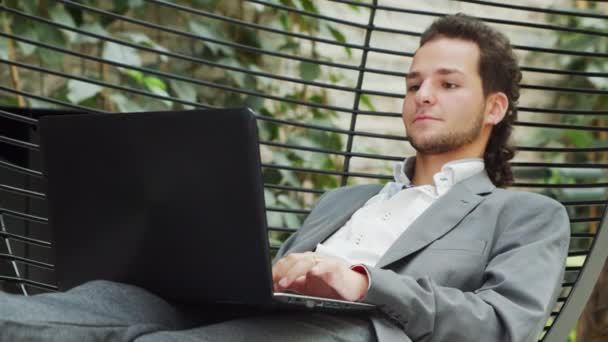 De jonge succesvolle blanke zakenman werkt in een lounge met een computer. Bedrijven, freelance en werk op afstand. — Stockvideo