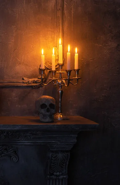 Läskigt skrattande pumpa och gammal skalle på antik gotisk öppen spis. Halloween, häxeri och magi. — Stockfoto
