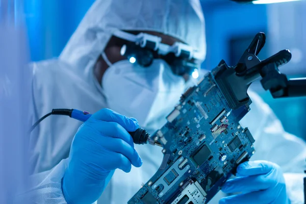 Professional African-American scientist works in a modern scientific laboratory for the research and development of microelectronics and processors. Microprocessor manufacturing worker uses computer