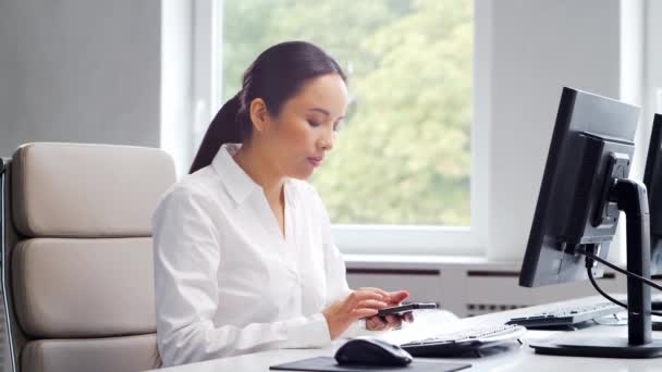 Modern bir ofiste masasında çalışan Asyalı bir iş kadını. Başarılı bir uzmanın işyeri. İş ve finans kavramı. — Stok video