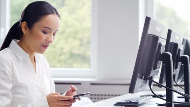 Mujer de negocios asiática trabajando en su mesa en una oficina moderna. El lugar de trabajo de un especialista exitoso. Concepto de negocio y finanzas. — Vídeos de Stock