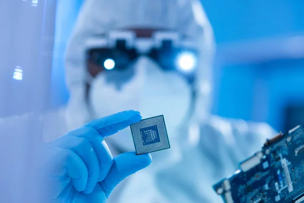 African-American scientist works in a modern scientific laboratory for the research and development of microelectronics and processors. Manufacturing worker uses computer technology and equipment. — Stock Photo, Image