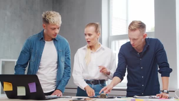 Team av unga startupers arbetar vid bordet på kontoret, diskuterar strategi och utvecklingsplan för företaget. Affärs-, innovations-, idé- och teamwork-koncept. — Stockvideo