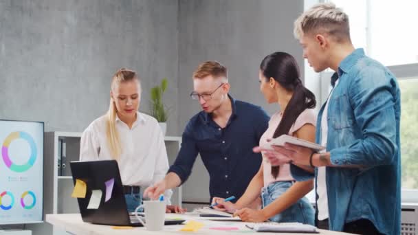 Tým mladých startupů pracuje u stolu v kanceláři a diskutuje o strategii a rozvojovém plánu společnosti. Podnikání, inovace, brainstorming a týmová práce koncepce. — Stock video