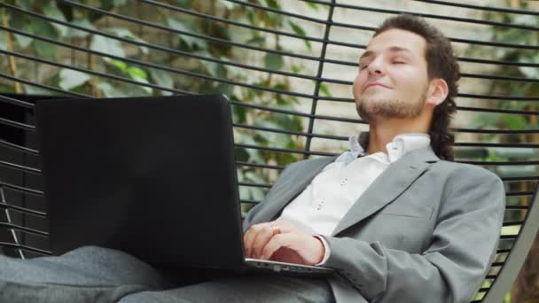 De jonge succesvolle blanke zakenman werkt in een lounge met een computer. Bedrijven, freelance en werk op afstand. — Stockvideo