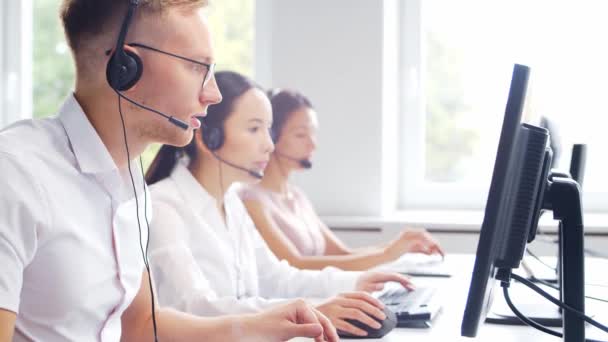 Diverse team van professionals werkt in de telefoon support office. Werkdag van sales managers in het call center. Concept van business, telefonische consultancy en probleemoplossing. — Stockvideo