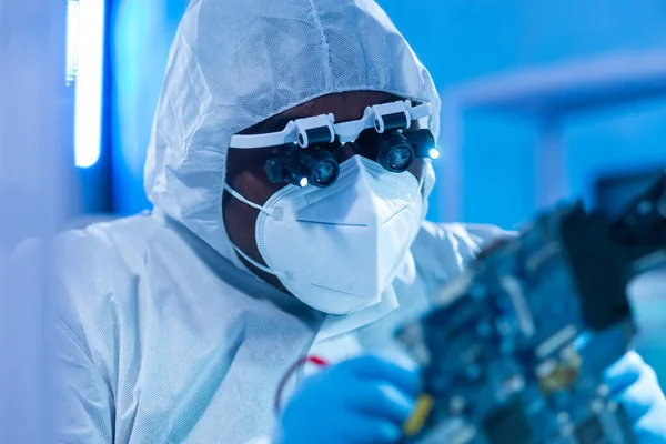 African-American scientist works in a modern scientific laboratory for the research and development of microelectronics and processors. Manufacturing worker uses computer technology and equipment. — Stock Photo, Image