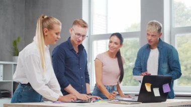 Genç girişimcilerden oluşan bir ekip ofisteki masada çalışarak şirketin strateji ve geliştirme planını tartışıyor. İş, yenilik, beyin fırtınası ve takım çalışması kavramı.