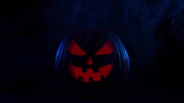 Enge lachende pompoen op een donkere achtergrond. Halloween, hekserij en magie. — Stockvideo