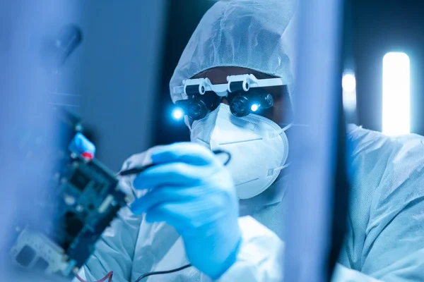 African-American scientist works in a modern scientific laboratory for the research and development of microelectronics and processors. Manufacturing worker uses computer technology and equipment. — Stock Photo, Image