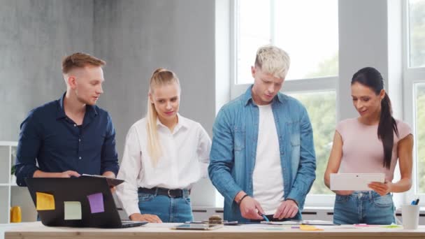 El equipo de jóvenes startups está trabajando en la mesa de la oficina, discutiendo la estrategia y el plan de desarrollo de la empresa. Negocios, innovación, lluvia de ideas y trabajo en equipo. — Vídeos de Stock