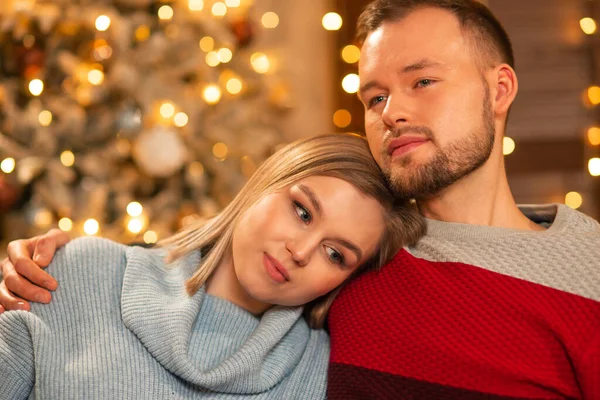 Pareja joven y cariñosa celebrando la Navidad en casa. Joven y su atractiva novia en el interior de una casa con un árbol de Navidad. — Foto de Stock