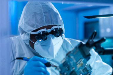 Profesyonel Afro-Amerikan bilim adamı, mikro elektronik ve işlemcilerin araştırılması ve geliştirilmesi için modern bir bilim laboratuvarında çalışıyor. Mikroişlemci imalat işçisi bilgisayar teknolojisi ve ekipmanı kullanıyor.