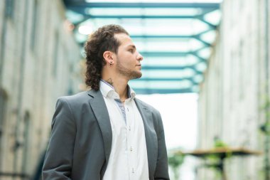 Genç ve başarılı bir iş adamı akıllı telefon kullanarak dışarıda çalışıyor. Sıradan giysili bir adam. İş, serbest meslek ve uzaktan çalışma kavramı.