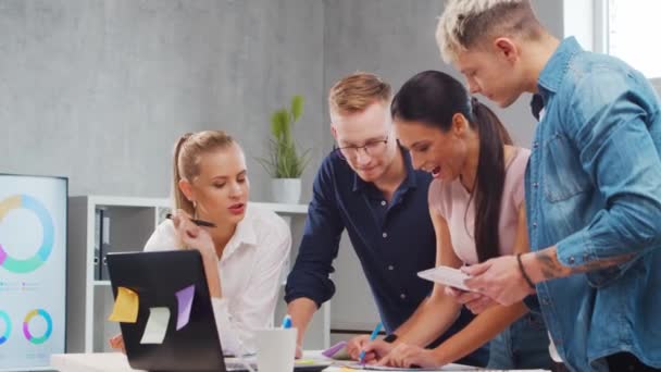 Team av unga startupers arbetar vid bordet på kontoret, diskuterar strategi och utvecklingsplan för företaget. Affärs-, innovations-, idé- och teamwork-koncept. — Stockvideo