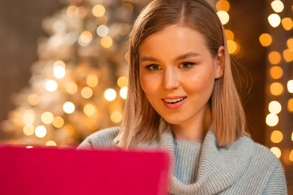 Giovane coppia amorevole che celebra il Natale a casa. Giovane uomo e la sua ragazza attraente in un interno di casa con un albero di Natale. — Foto Stock