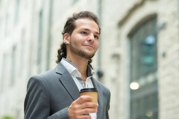 Un jeune homme d'affaires prospère marche dans la rue. Homme en tenue décontractée. Entreprises, freelance et télétravail. — Photo