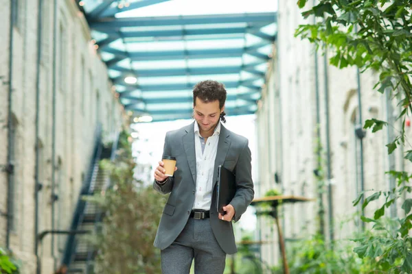 A young successful businessman is walking down the street. Man in a casual wear. Business, freelance and remote work. — Stock Photo, Image