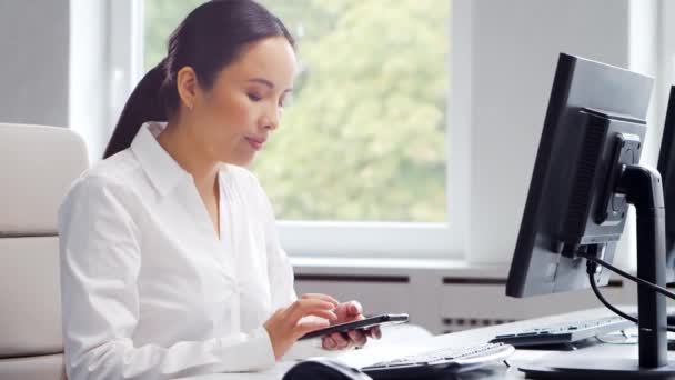 Mujer de negocios asiática trabajando en su mesa en una oficina moderna. El lugar de trabajo de un especialista exitoso. Concepto de negocio y finanzas. — Vídeos de Stock