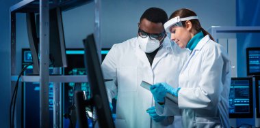 Bir grup mikro elektronik mühendisi modern bir mikroişlemci laboratuvarında tartışıyorlar. Elektronik tasarımcıların işyeri. Yenilikler ve icatlar kavramı.